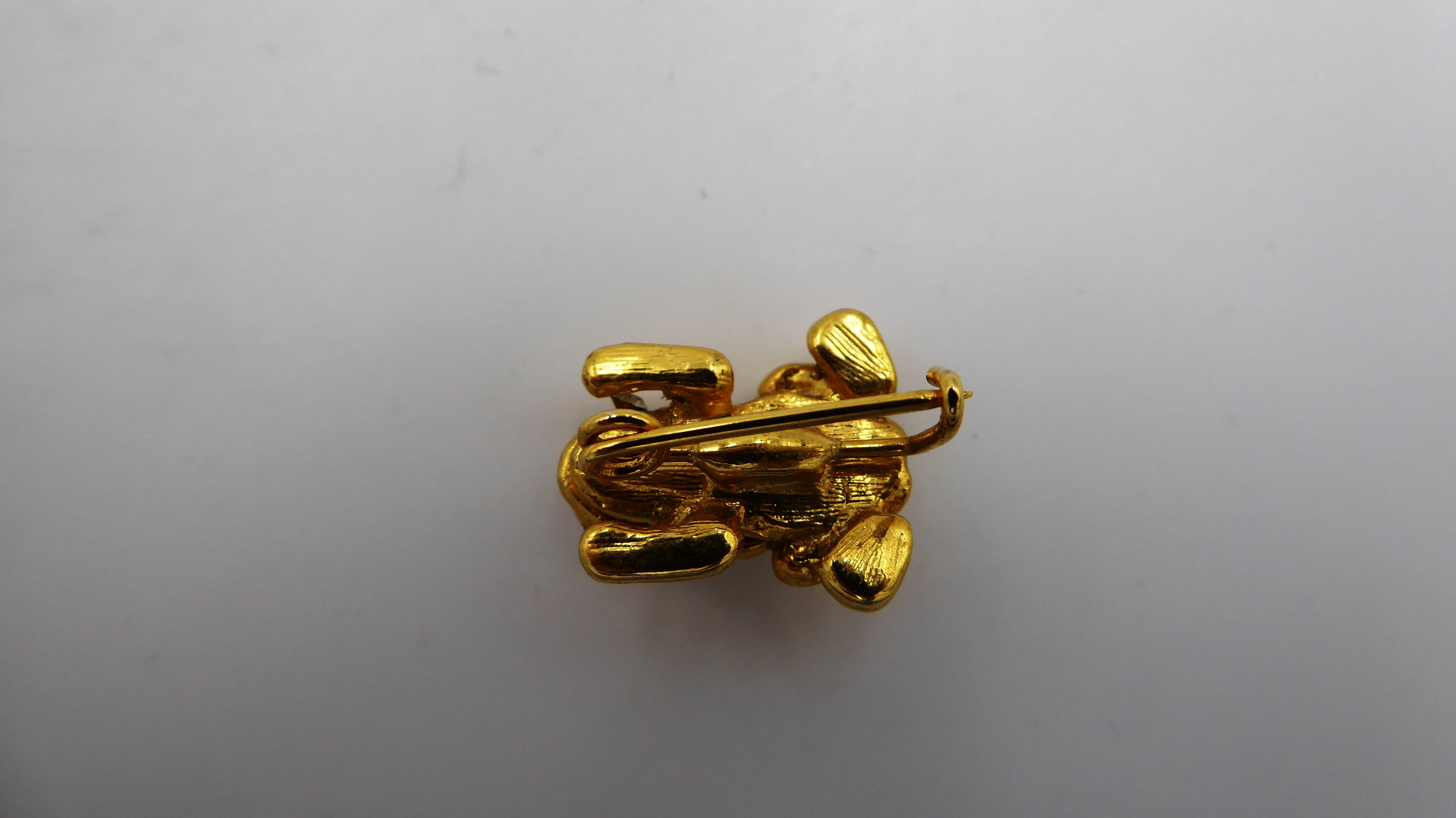 Belle petite broche en métal doré et strass