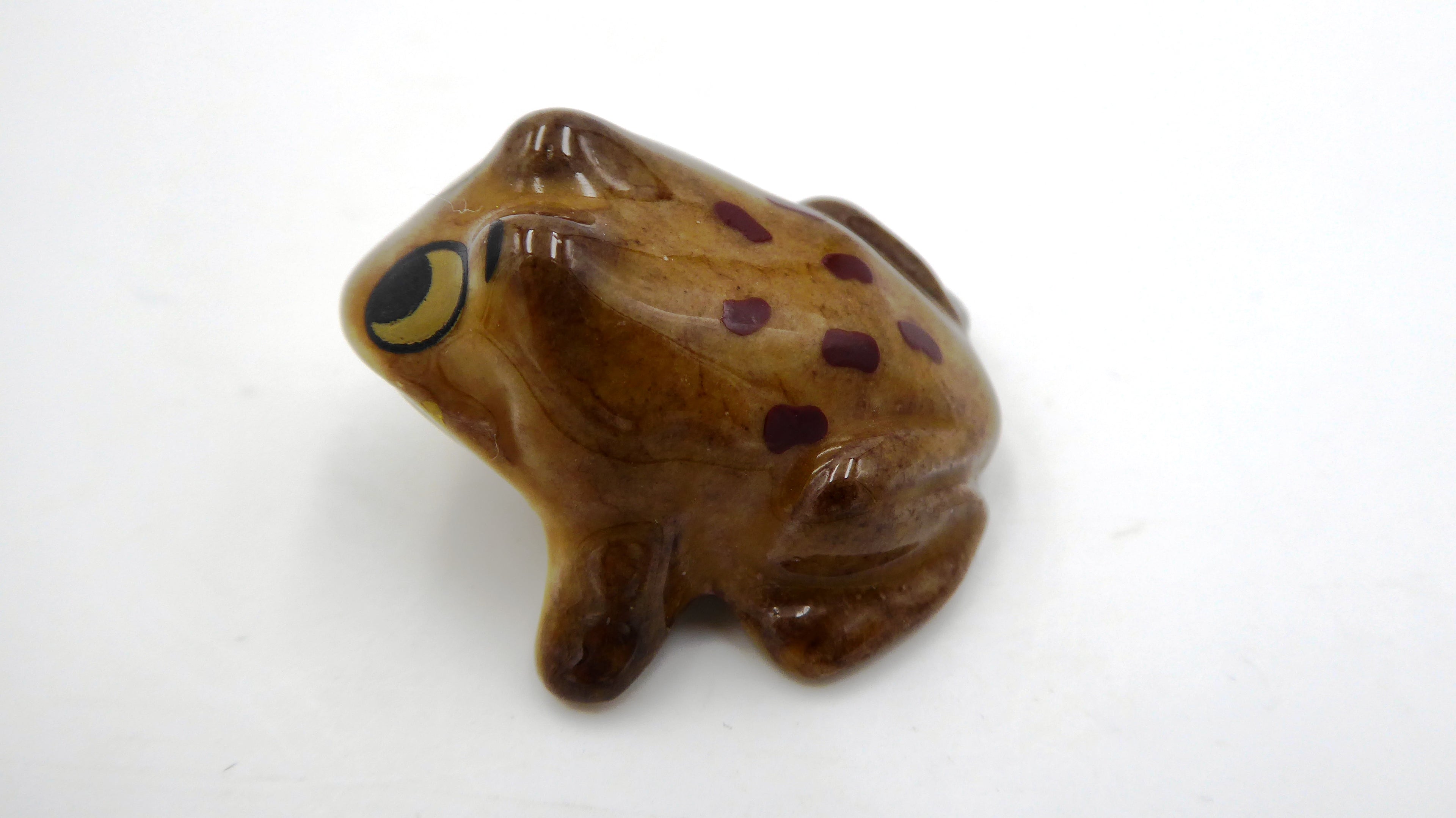 Petite grenouille en céramique marron à pois noirs