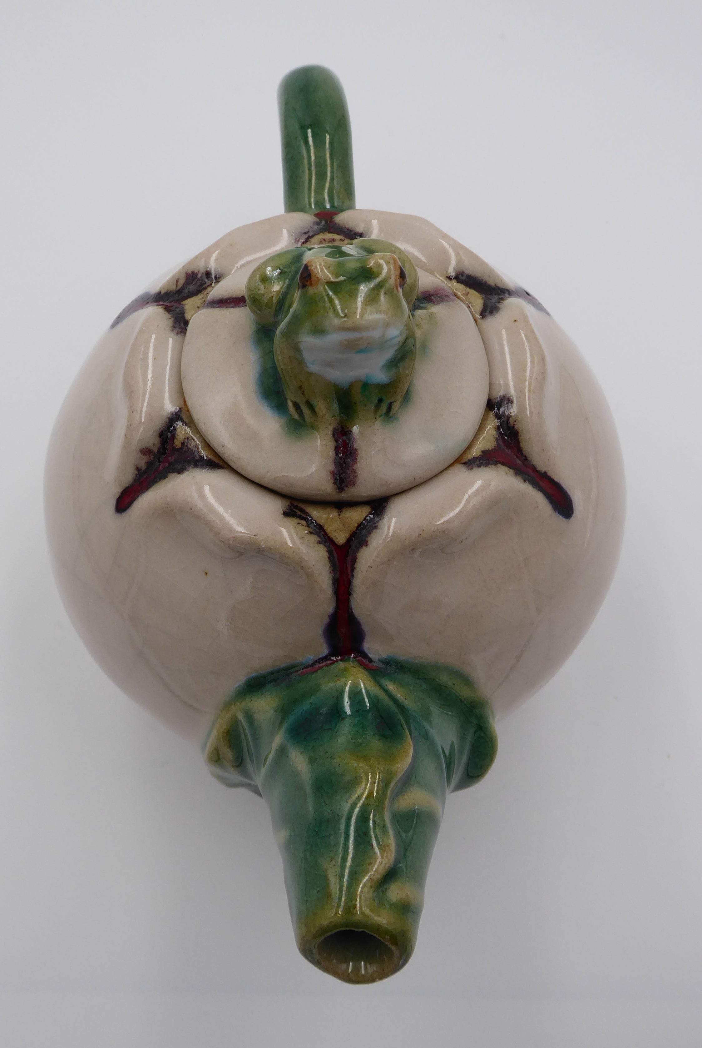 Théière en céramique beige surmontée d'une grenouille