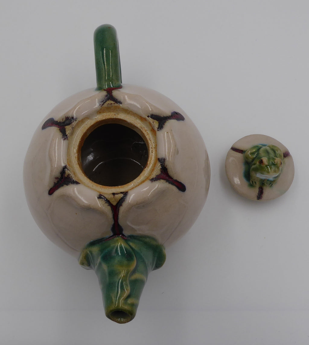 Théière en céramique beige surmontée d'une grenouille