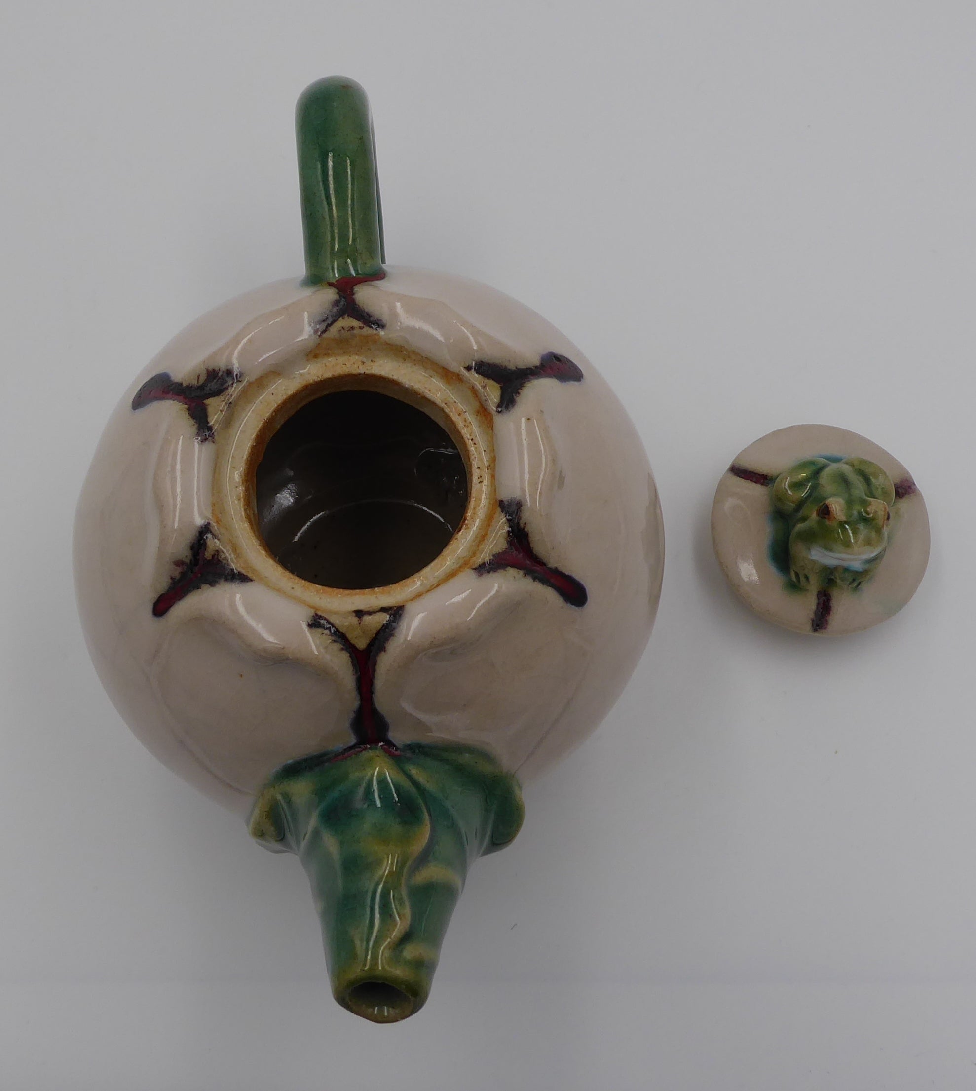 Théière en céramique beige surmontée d'une grenouille