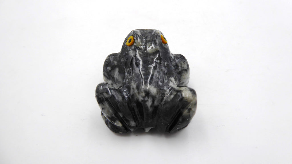 Petite grenouille en pierre tachetée aux yeux jaunes
