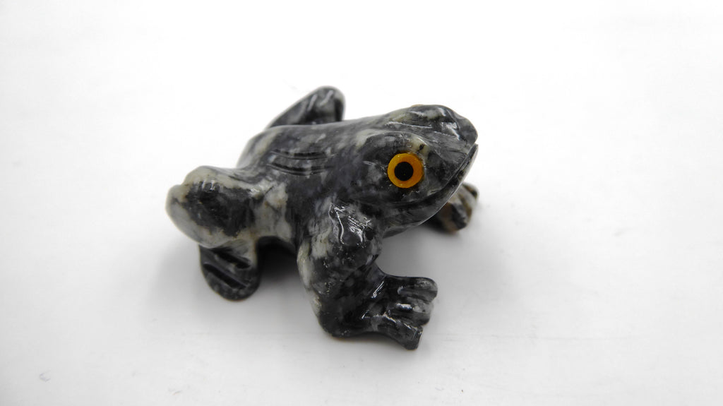 Petite grenouille en pierre tachetée aux yeux jaunes