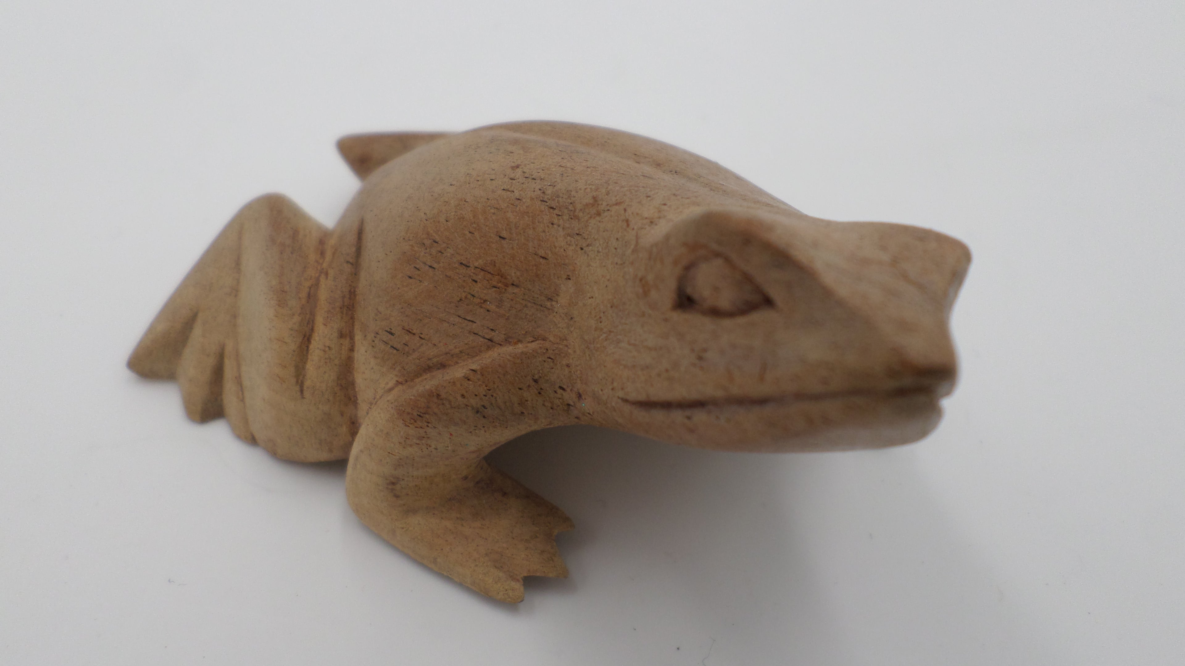 Petite grenouille taillée dans un bloc de bois