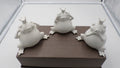 Trois grenouilles en céramique blanche