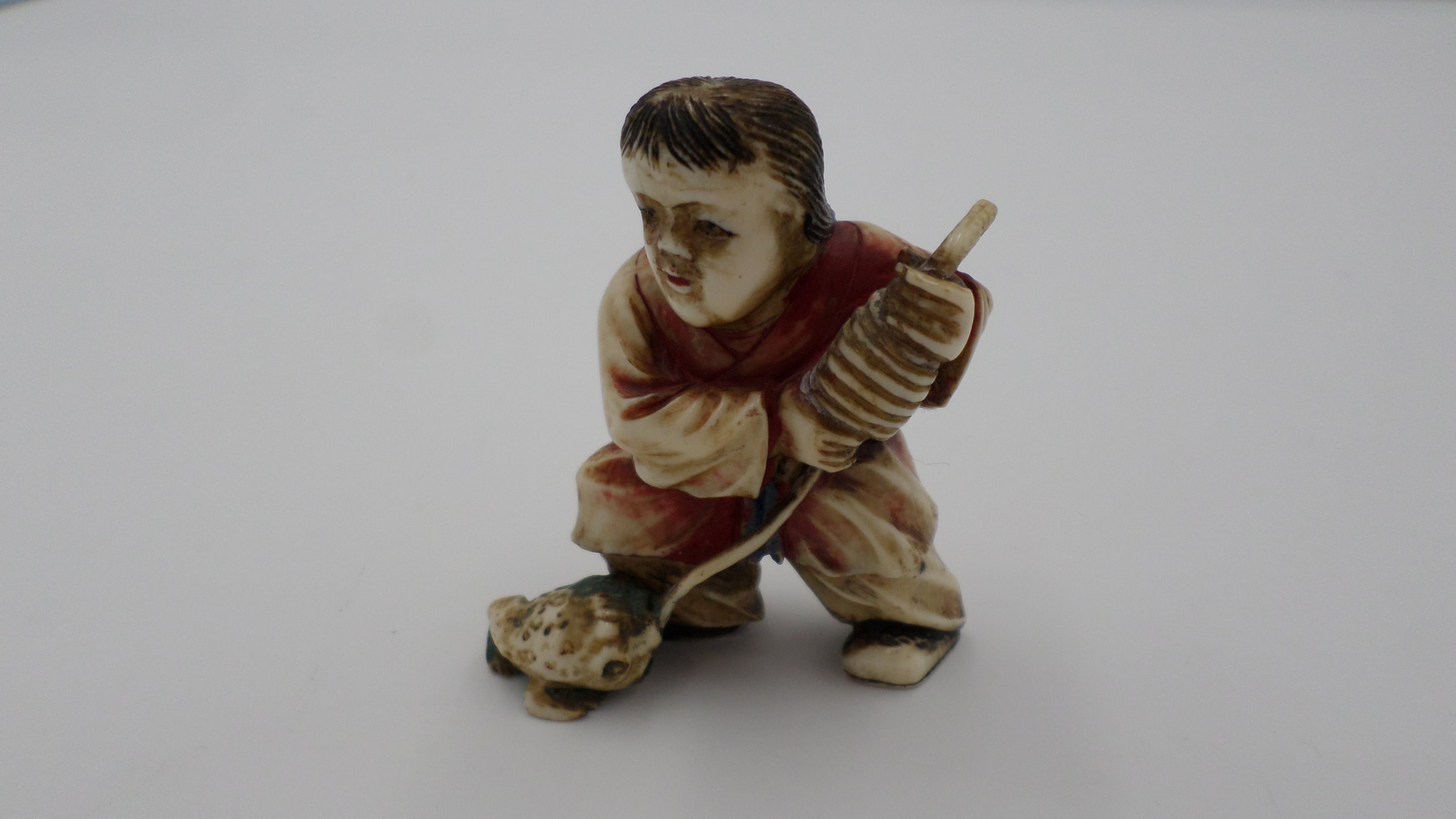 Statuette CHINOISE en ivoire polychrome représentant un enfant Karako s'amusant avec une grenouille