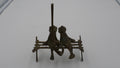 Couple de grenouilles en laiton vieilli sur un banc