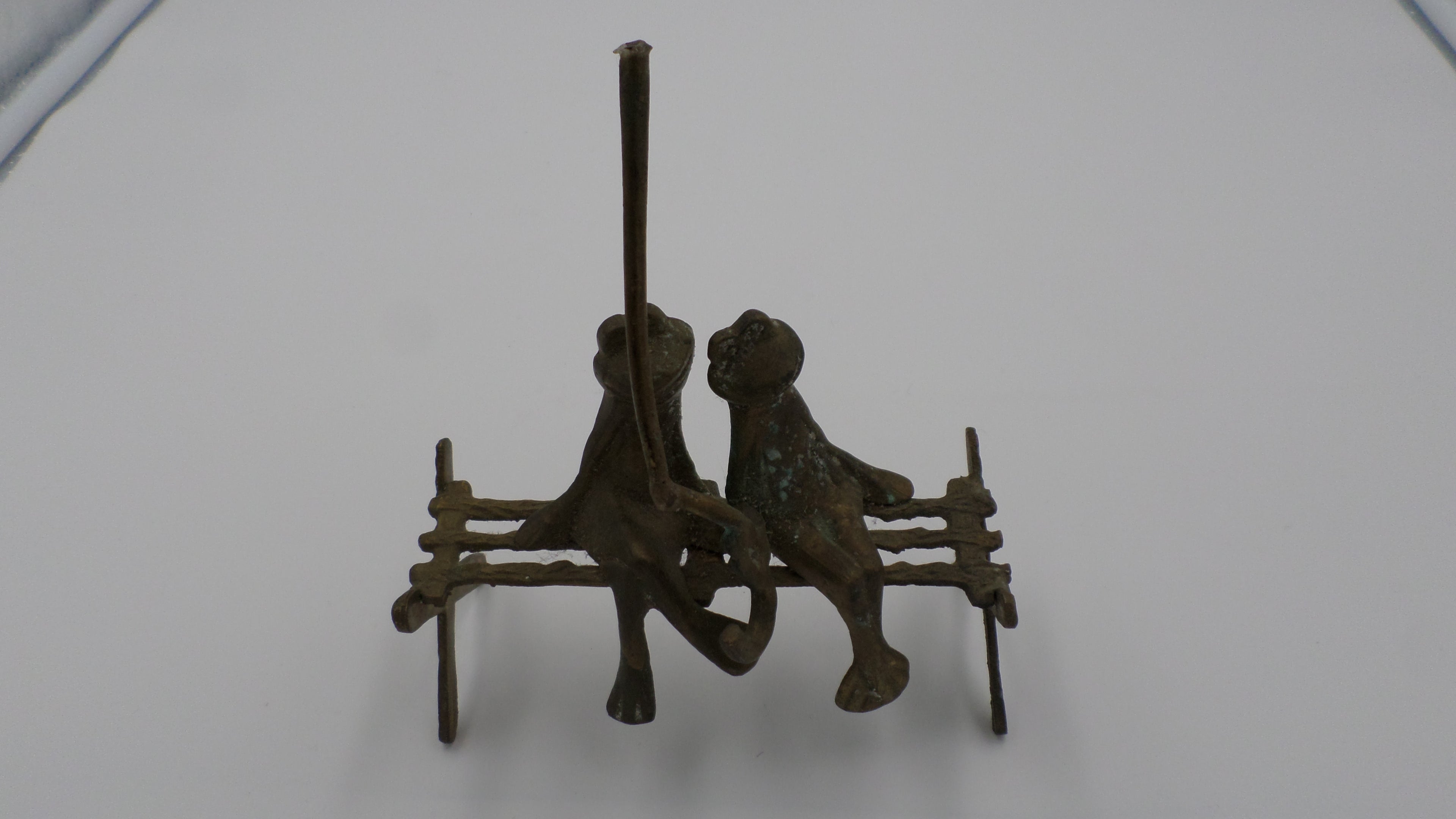 Couple de grenouilles en laiton vieilli sur un banc