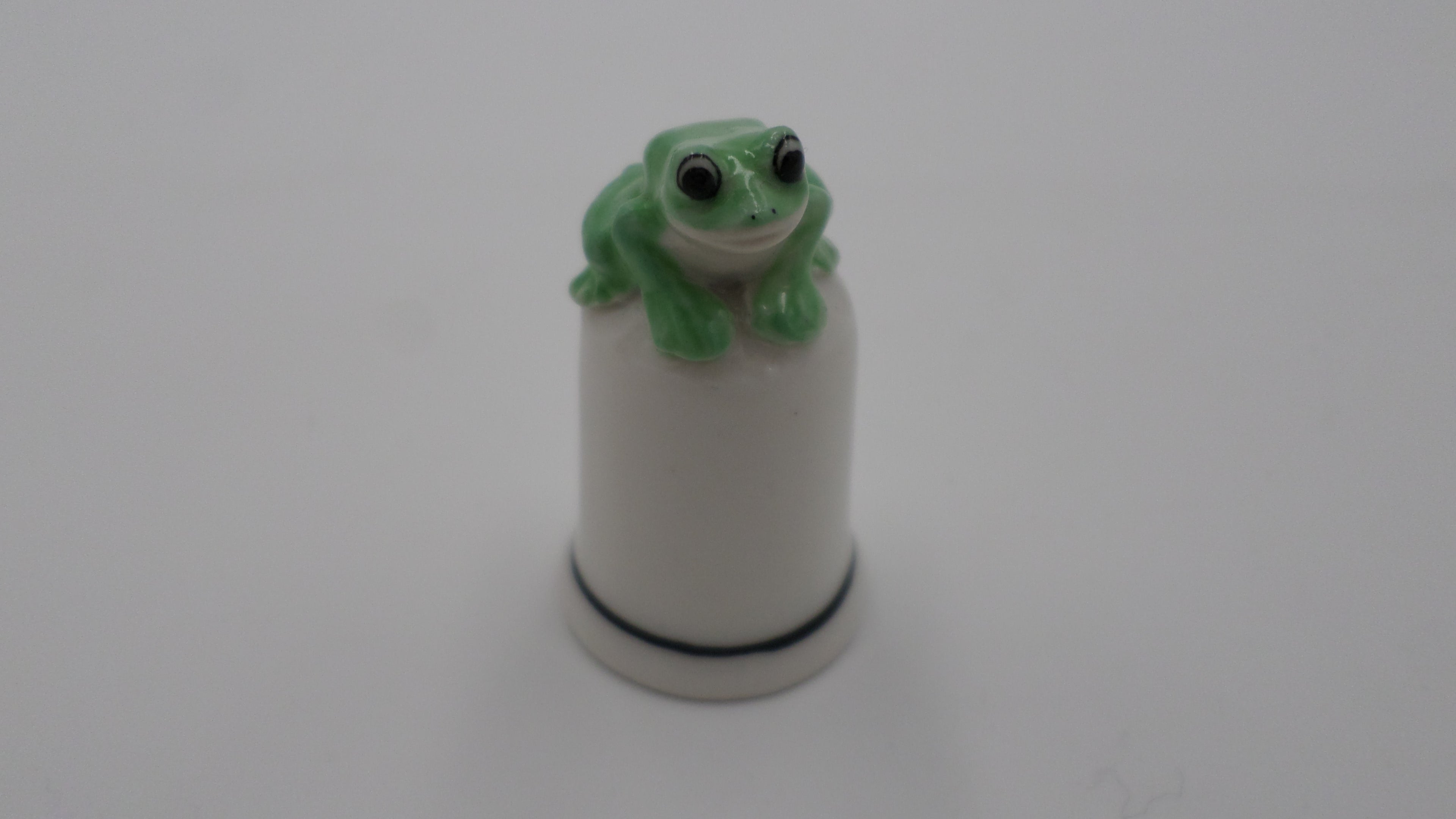 Dé en porcelaine blanc surmonté d'une grenouille verte