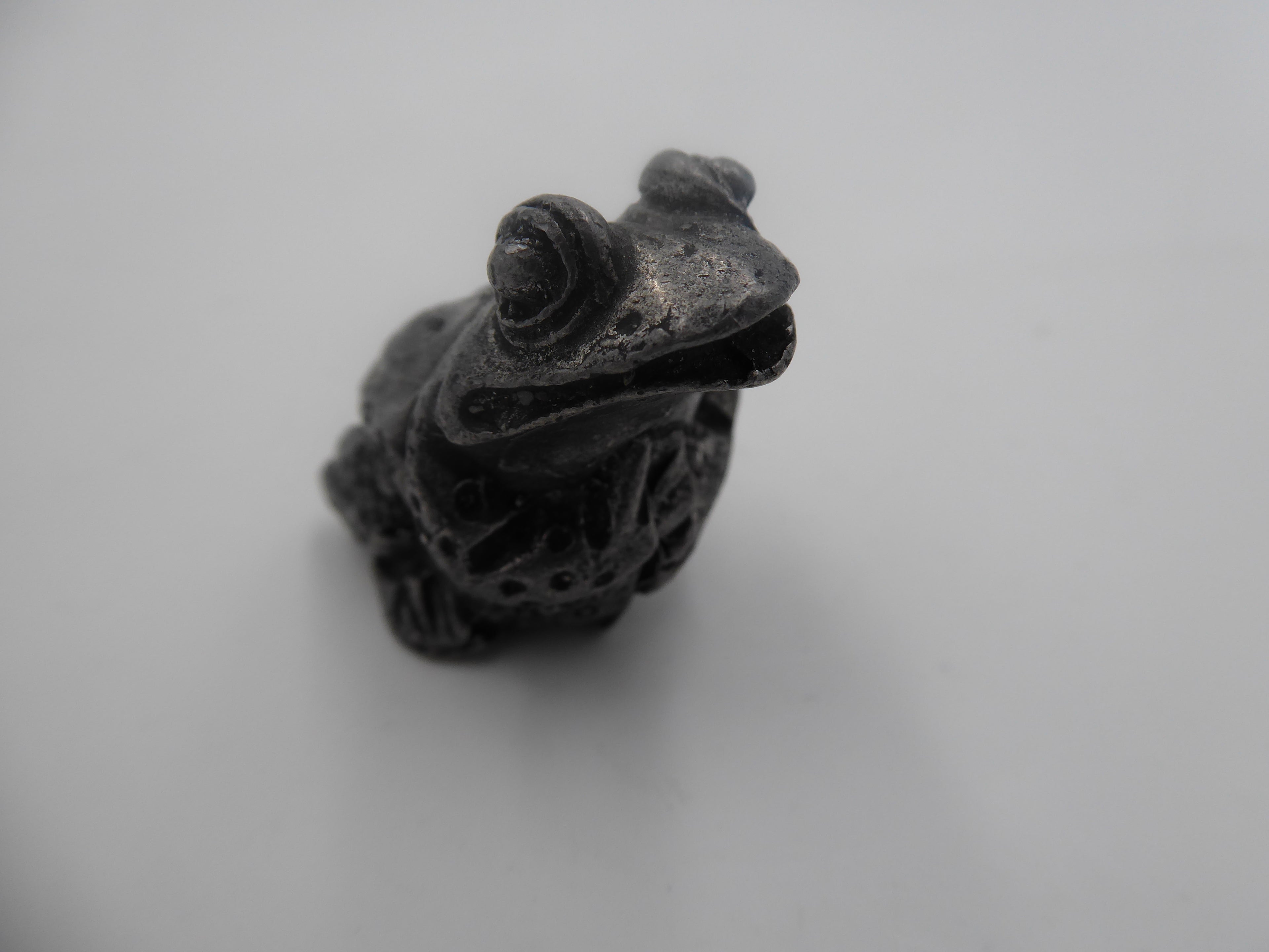 Grenouille en étain avec ses pattes sur le ventre