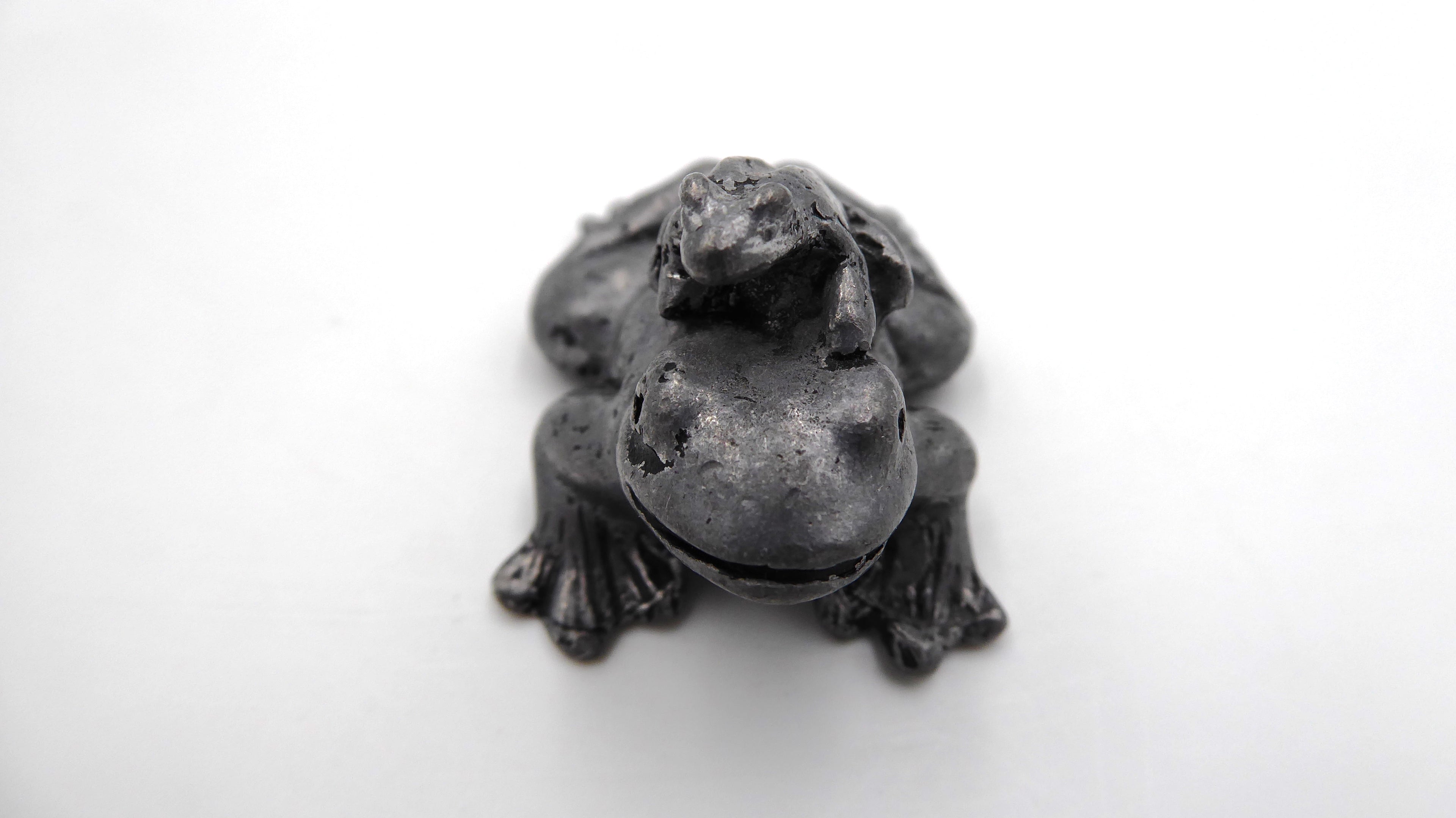 Petite maman grenouille en étain avec son bébé sur le dos