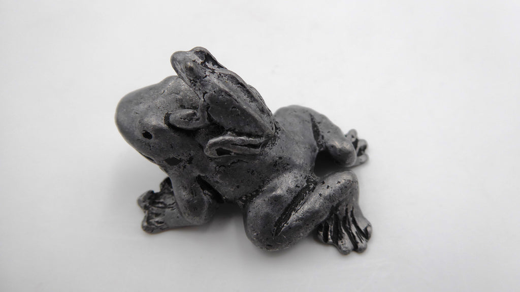 Petite maman grenouille en étain avec son bébé sur le dos