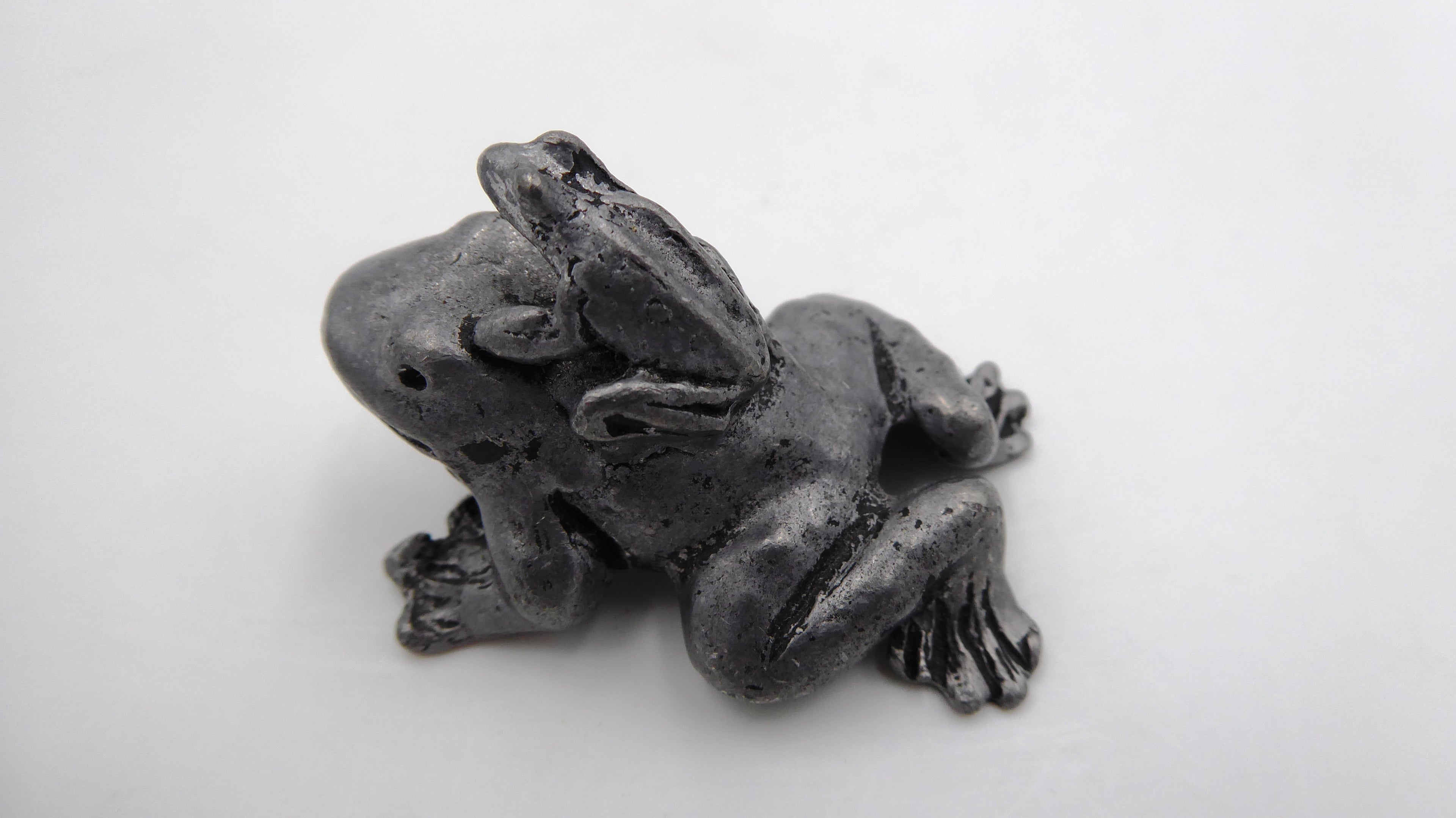 Petite maman grenouille en étain avec son bébé sur le dos