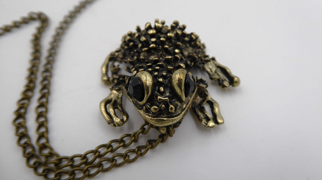 Pendentif ancien métal doré noirci (Laiton ?) avec deux yeux en brillants biseautés