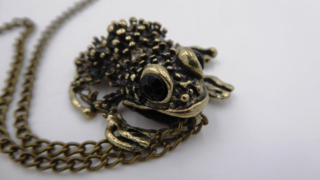 Pendentif ancien métal doré noirci (Laiton ?) avec deux yeux en brillants biseautés