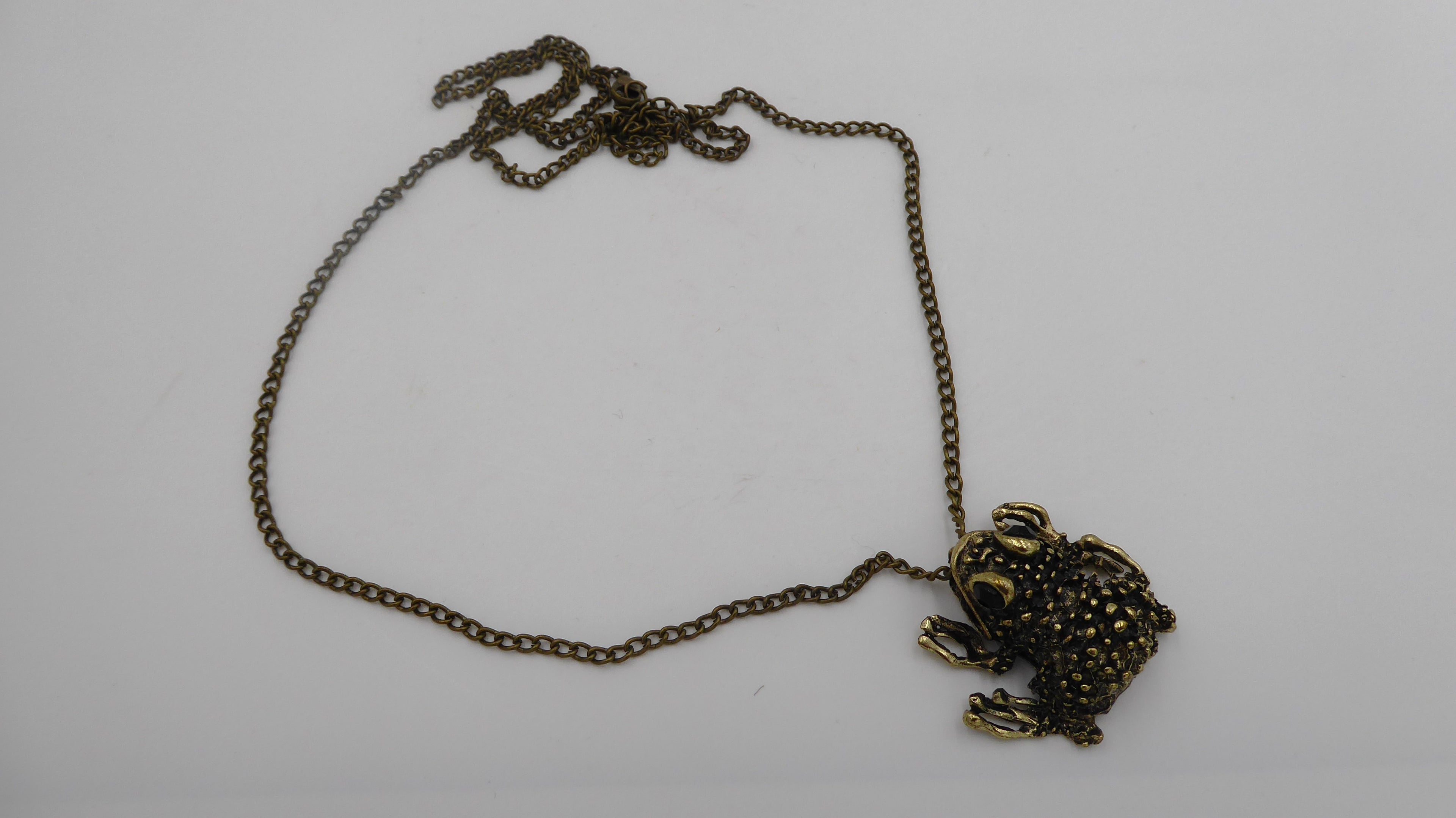 Pendentif ancien métal doré noirci (Laiton ?) avec deux yeux en brillants biseautés