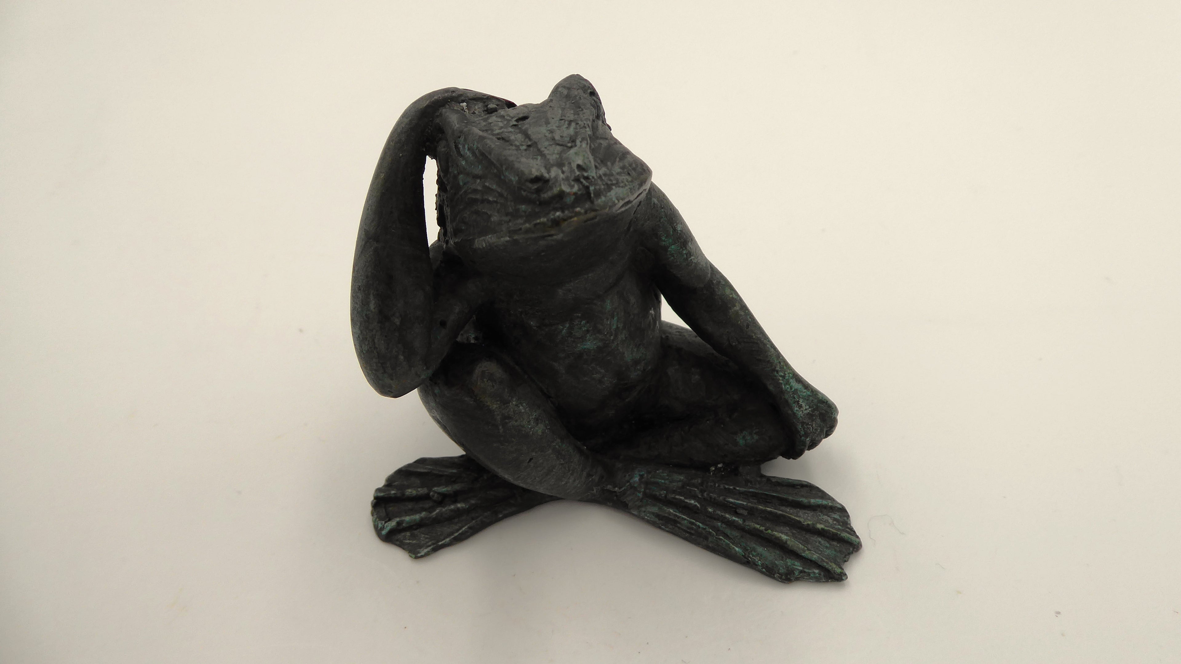 Beau et ancien petit bronze grenouille qui réfléchie