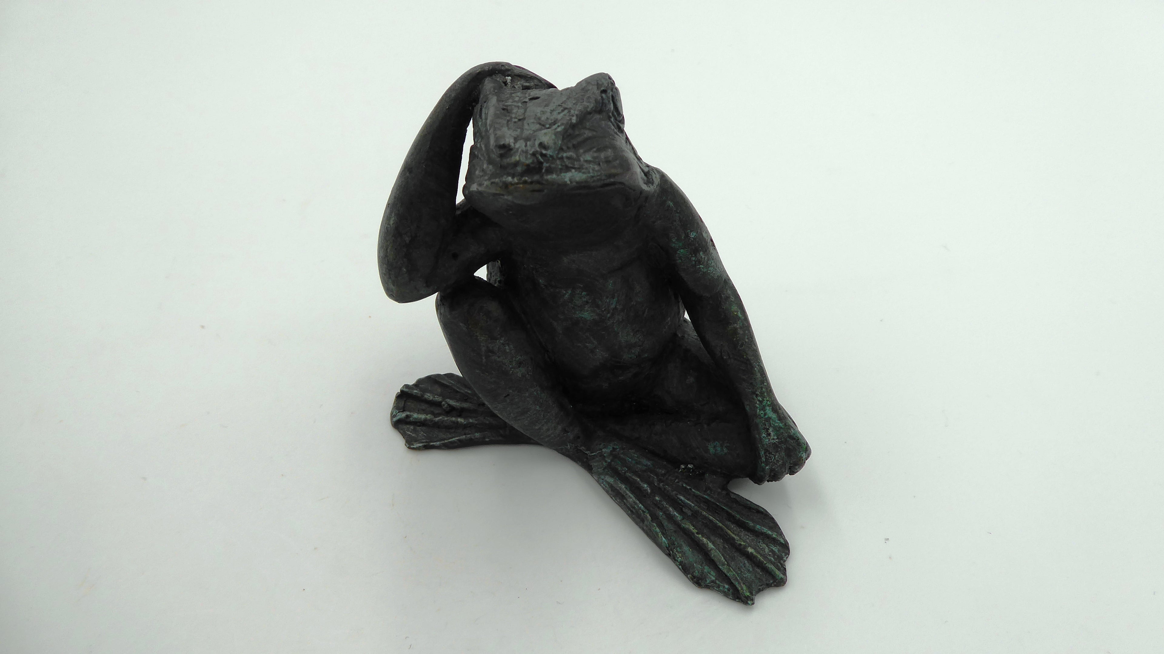 Beau et ancien petit bronze grenouille qui réfléchie