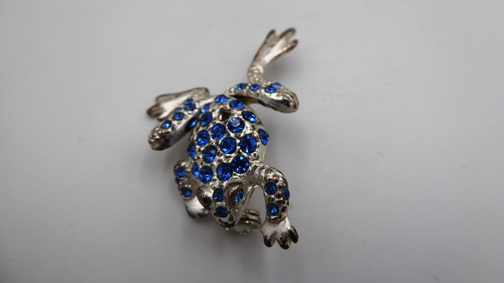Belle petite broche en métal argenté et strass