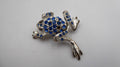 Belle petite broche en métal argenté et strass