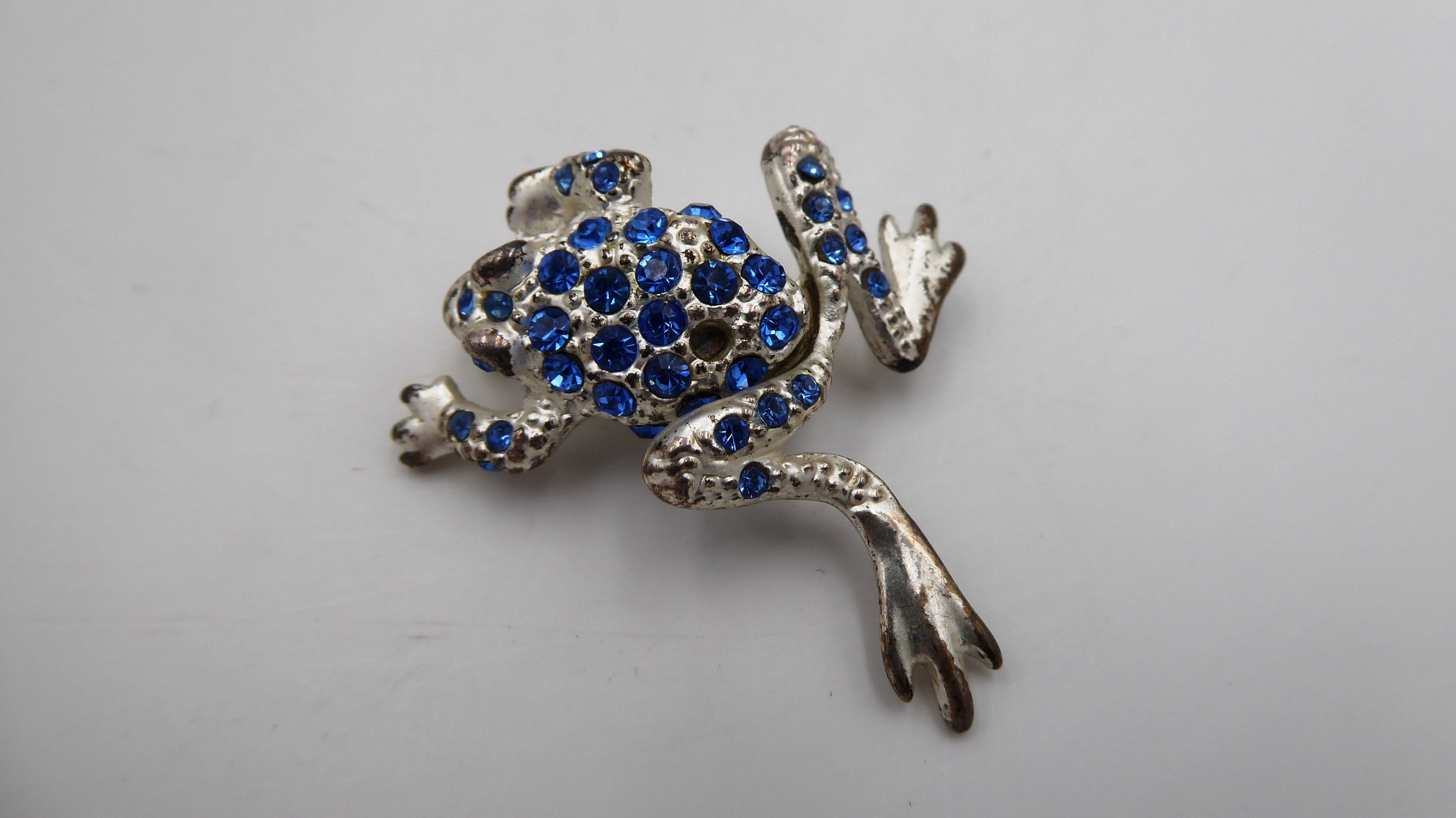 Belle petite broche en métal argenté et strass