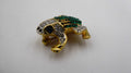 Belle petite broche en métal doré et strass