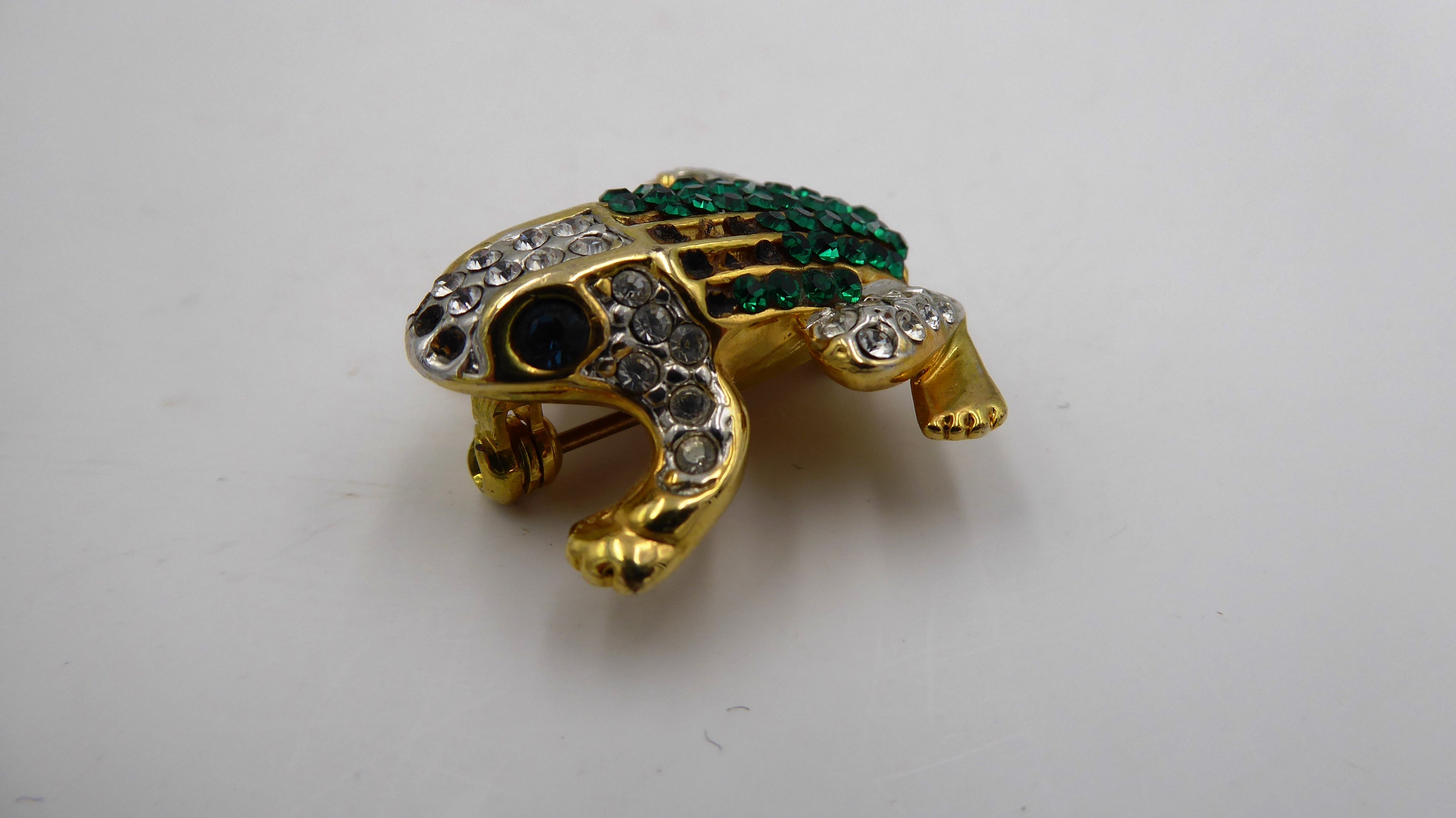 Belle petite broche en métal doré et strass
