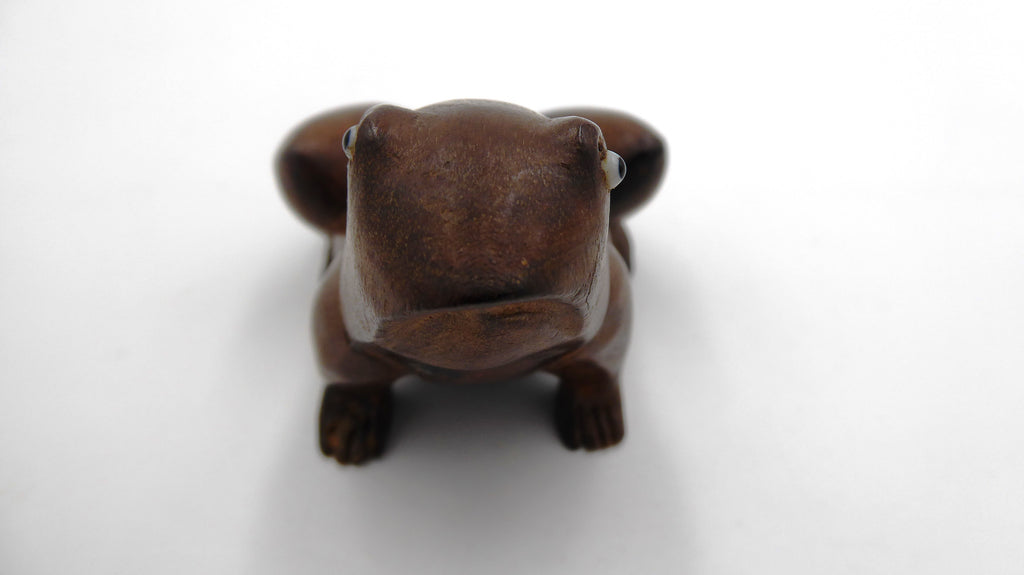 Grenouille en bois foncé aux yeux noirs