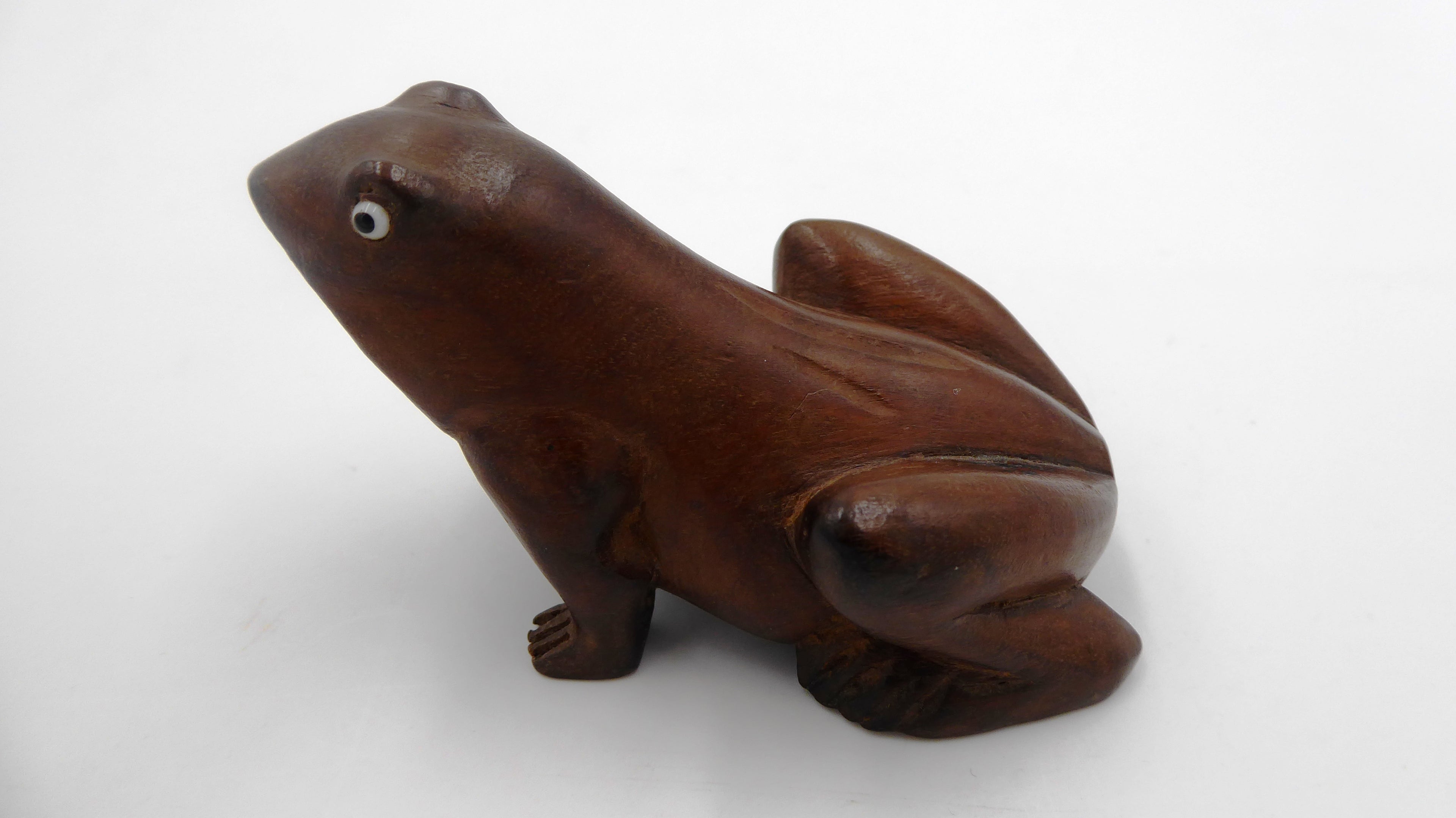Grenouille en bois foncé aux yeux noirs
