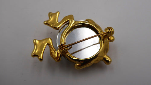 Broche grenouille en métal doré incrusté d'une pierre à facette