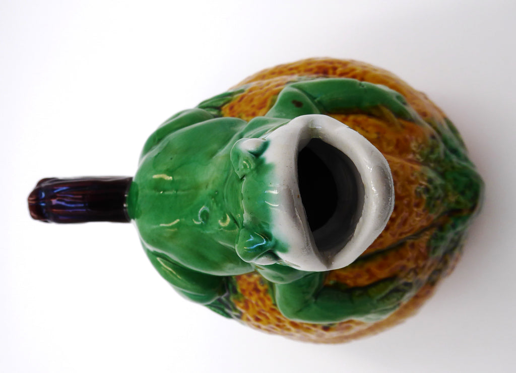 Broc en céramique grenouille sur un fruit