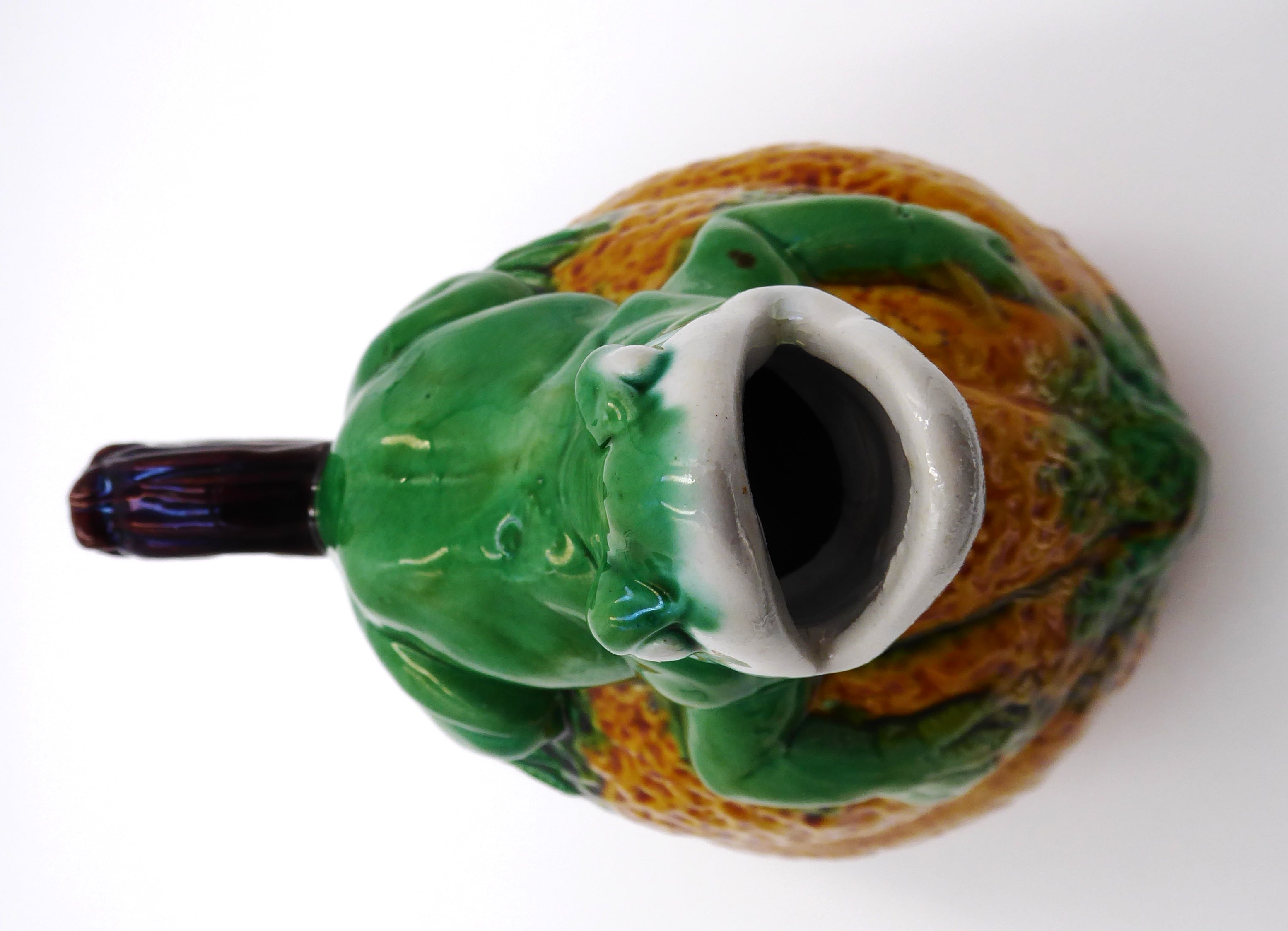 Broc en céramique grenouille sur un fruit