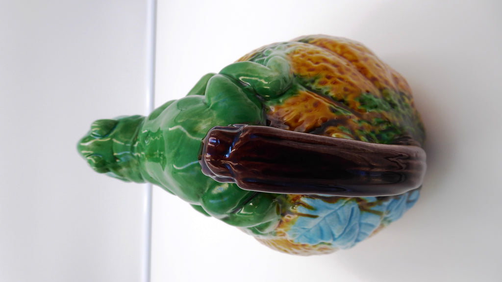 Broc en céramique grenouille sur un fruit