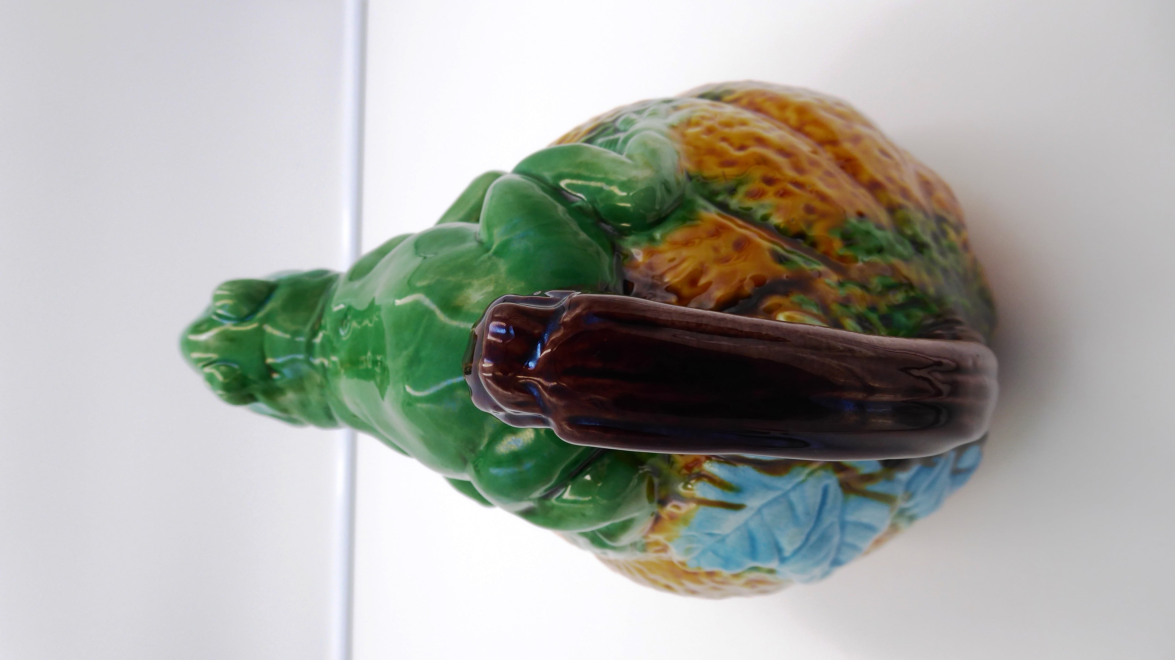 Broc en céramique grenouille sur un fruit