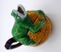 Broc en céramique grenouille sur un fruit