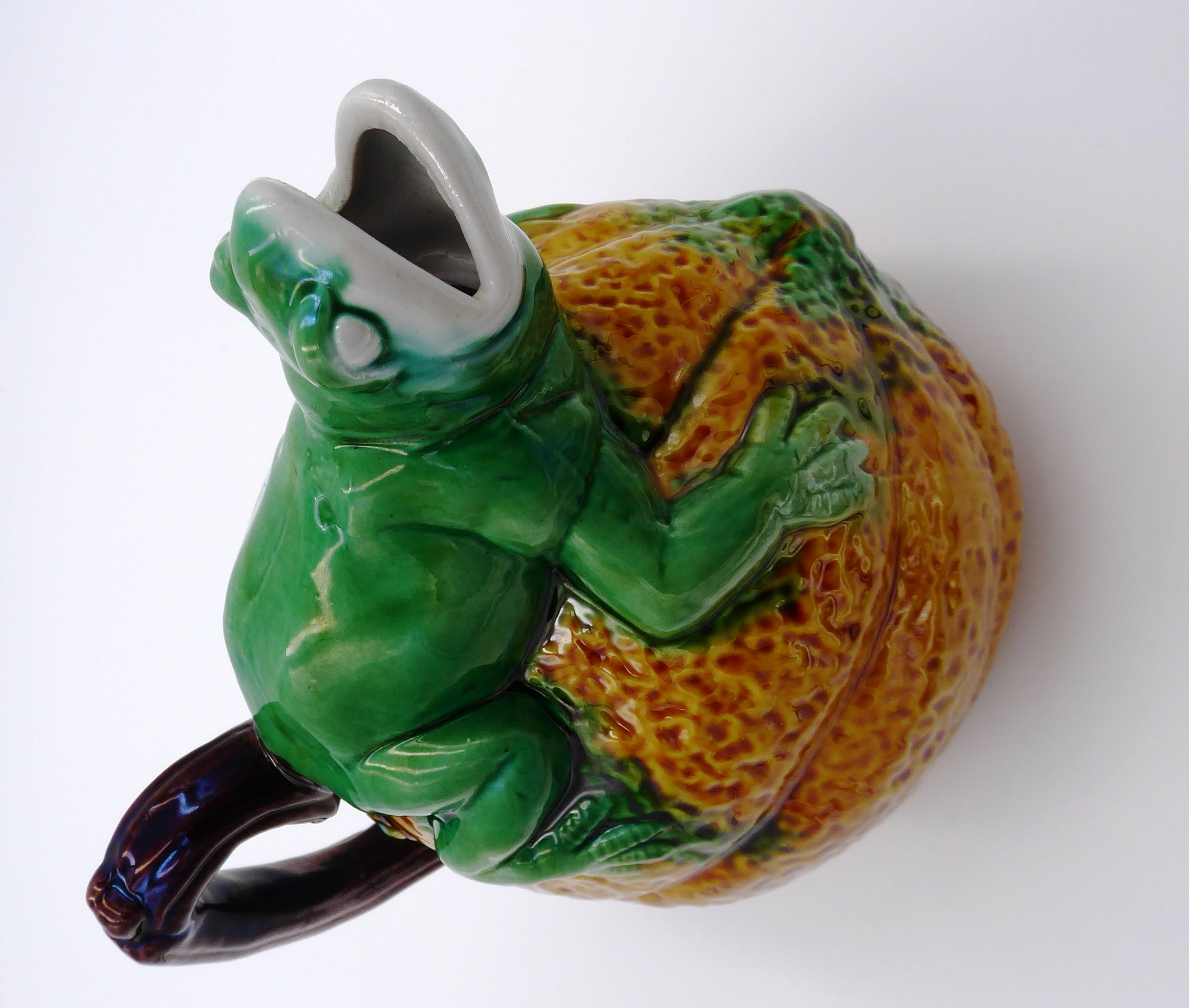 Broc en céramique grenouille sur un fruit