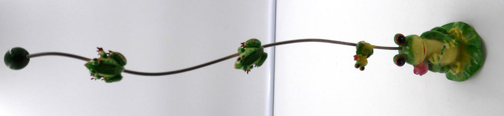 Trois petites grenouilles alimentées montant sur une tige supportée par une grenouille