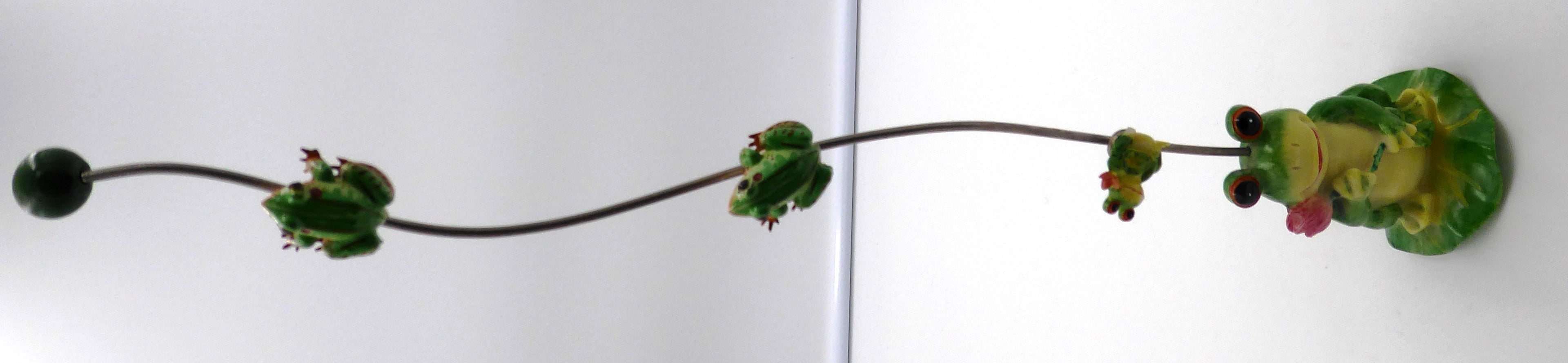 Trois petites grenouilles alimentées montant sur une tige supportée par une grenouille